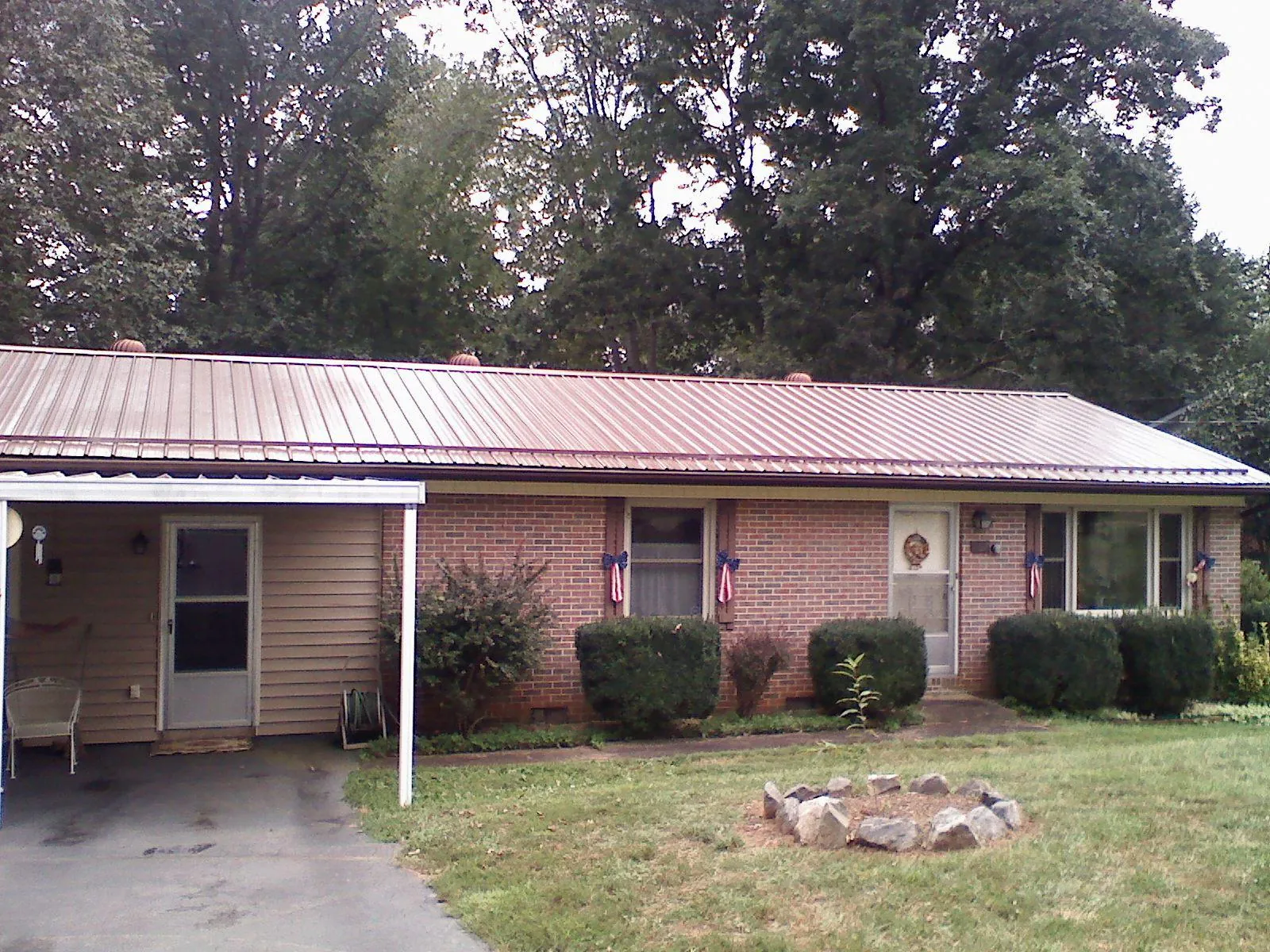 Bronze metal roof and carport on a brick ranch home — Roof Repair work by our crew in Charleston