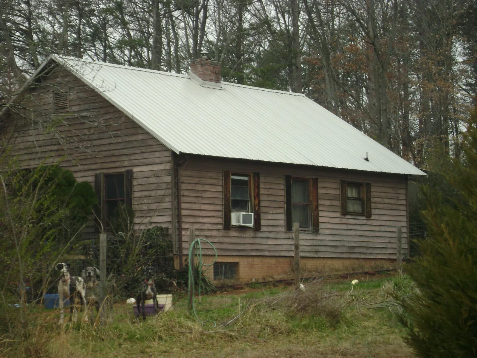 White metal roof on an old wood sided farmhouse, from a Metal Roof Installation job in Charleston